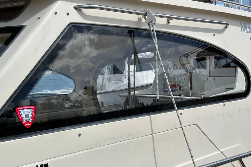 Slide: The Image of 2004 Mainship Pilot 30 boat with vessel safety check sticker, docked at marina. - 5