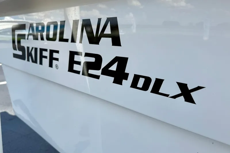 Slide: The Image of 2026 Carolina Skiff E24 DLX Kit Boat logo on white hull. - 17
