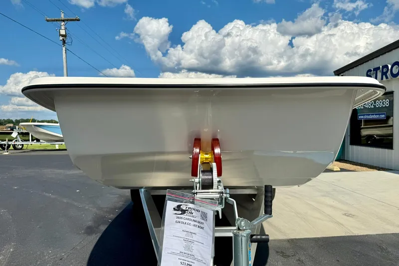 Slide: The Image of 2026 Carolina Skiff E24 DLX Kit Boat on trailer, sunny day, dealership background. - 6