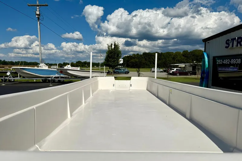 Slide: The Image of 2026 Carolina Skiff E24 DLX Kit Boat on display under a partly cloudy sky. - 9