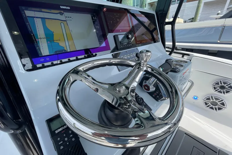 Slide: The Image of 2023 Crevalle 33 CSF boat dashboard with steering wheel and navigation display. - 11