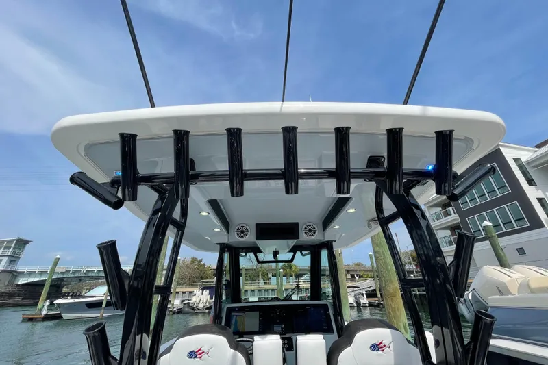 Slide: The Image of 2023 Crevalle 33 CSF boat with rod holders and modern console at marina. - 12