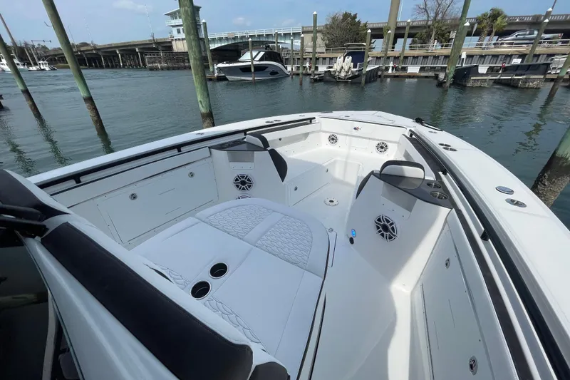 Slide: The Image of 2023 Crevalle 33 CSF boat interior with seating and speakers at a marina. - 19