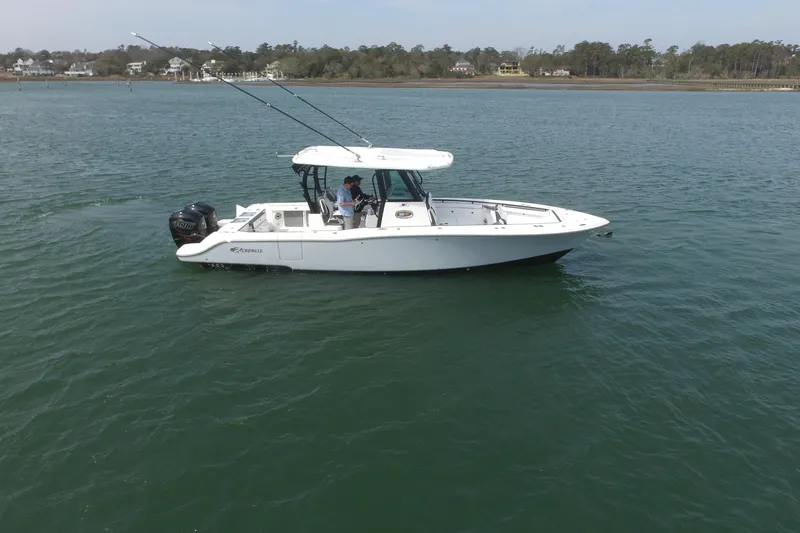 Slide: The Image of 2023 Crevalle 33 CSF boat on calm water, side view with fishing rods. - 9