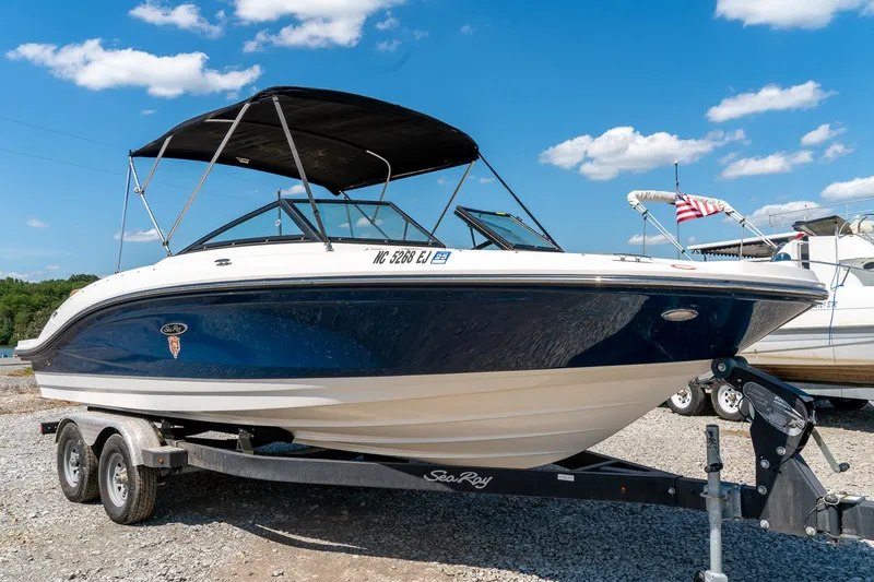 Slide: The Image of 2018 Sea Ray SPX 210 boat on trailer under clear blue sky. - 1