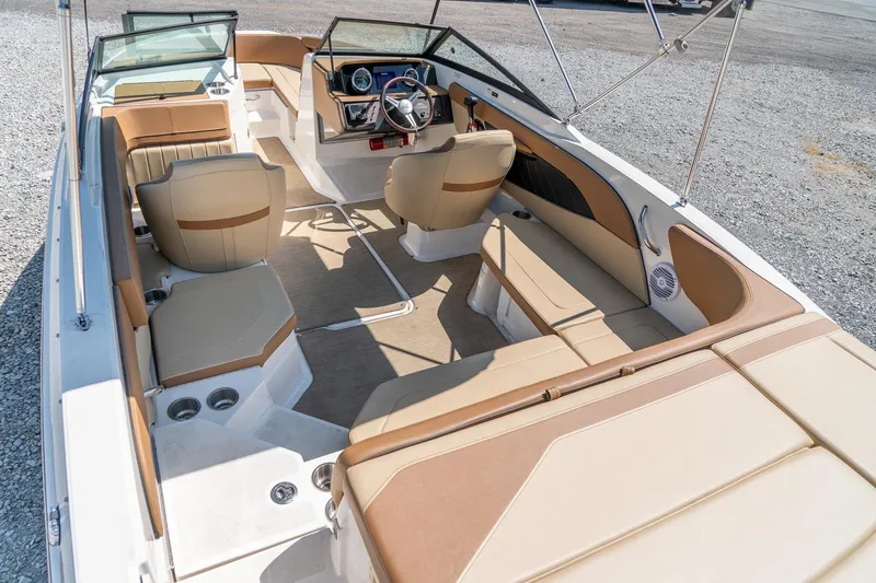Slide: The Image of 2018 Sea Ray SPX 210 boat interior with beige seating and modern dashboard. - 11