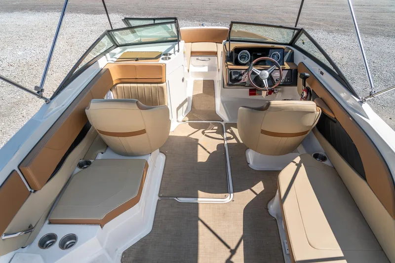 Slide: The Image of 2018 Sea Ray SPX 210 boat interior with beige seating and modern dashboard. - 12