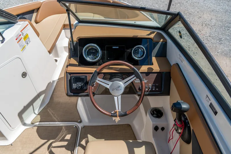 Slide: The Image of 2018 Sea Ray SPX 210 boat cockpit with steering wheel and dashboard controls. - 17