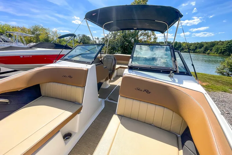 Slide: The Image of 2018 Sea Ray SPX 210 boat with tan seating, docked by a scenic lake. - 19