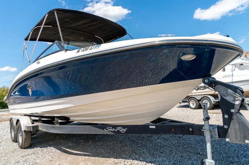 Slide: The Image of 2018 Sea Ray SPX 210 boat on trailer under clear blue sky. - 2
