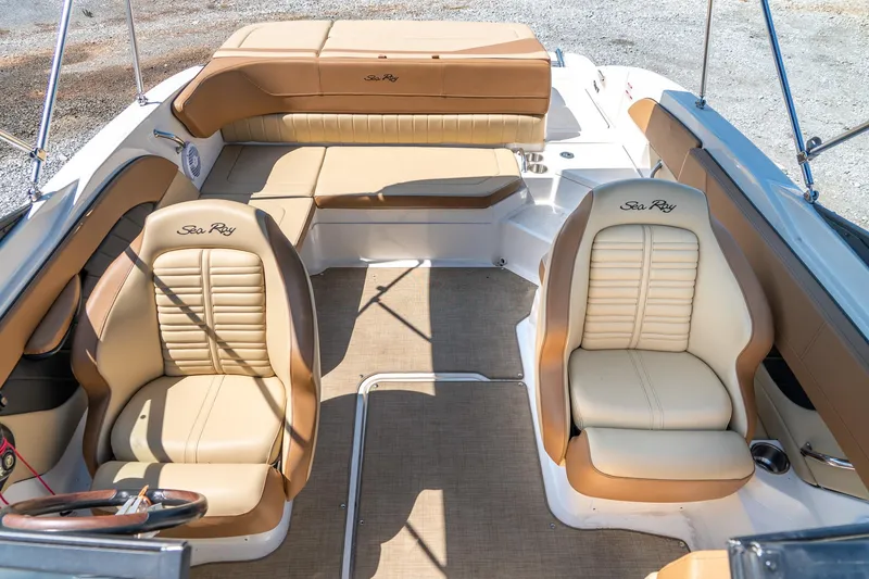 Slide: The Image of 2018 Sea Ray SPX 210 boat interior with tan leather seating and steering wheel. - 20