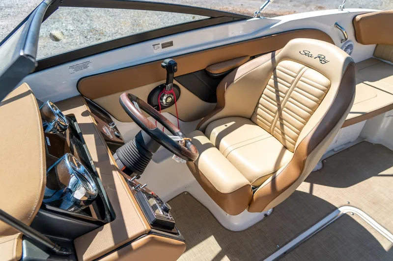 Slide: The Image of 2018 Sea Ray SPX 210 boat interior with tan leather seating and steering wheel. - 21