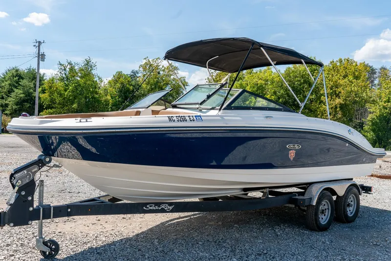 Slide: The Image of 2018 Sea Ray SPX 210 boat on trailer, blue and white, parked outdoors. - 5