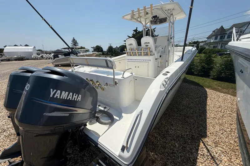 Slide: The Image of 2009 Century 2901 Center Console boat with dual Yamaha engines, parked on gravel. - 3