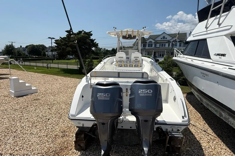 Slide: The Image of 2009 Century 2901 Center Console boat with twin 250 horsepower engines, parked on gravel. - 4