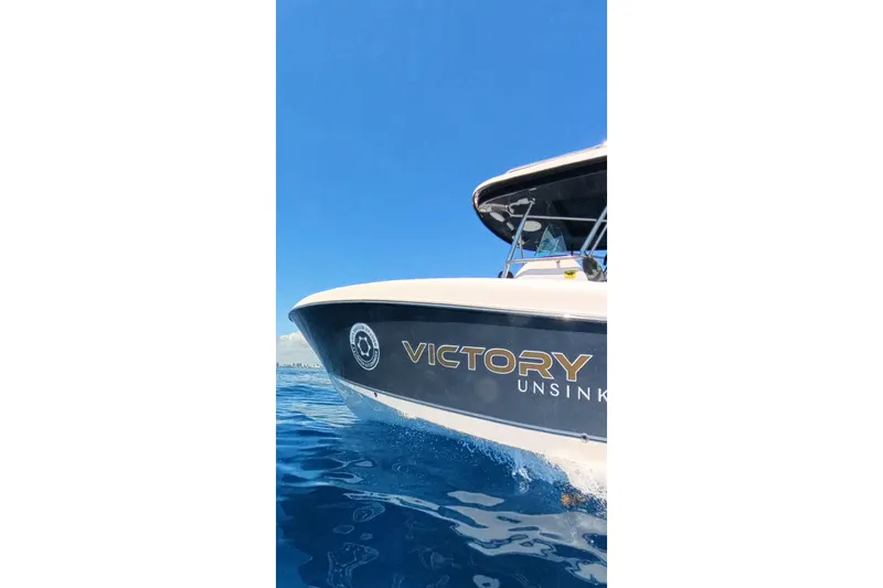 Slide: The Image of 2024 Victory Yachts V300 cruising on clear blue water under a bright sky. - 11