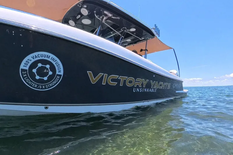 Slide: The Image of 2024 Victory Yachts V300 on water, showcasing unsinkable design and vacuum infusion technology. - 12