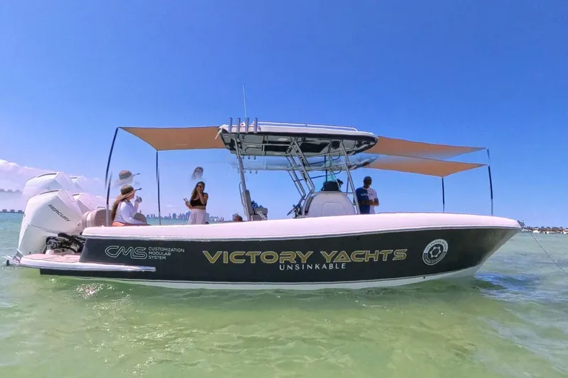 Slide: The Image of 2024 Victory Yachts V300 boat on water, featuring sunshades and passengers enjoying the ride. - 13