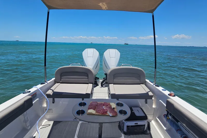 Slide: The Image of 2024 Victory Yachts V300 on open water, featuring spacious seating and a table with snacks. - 5