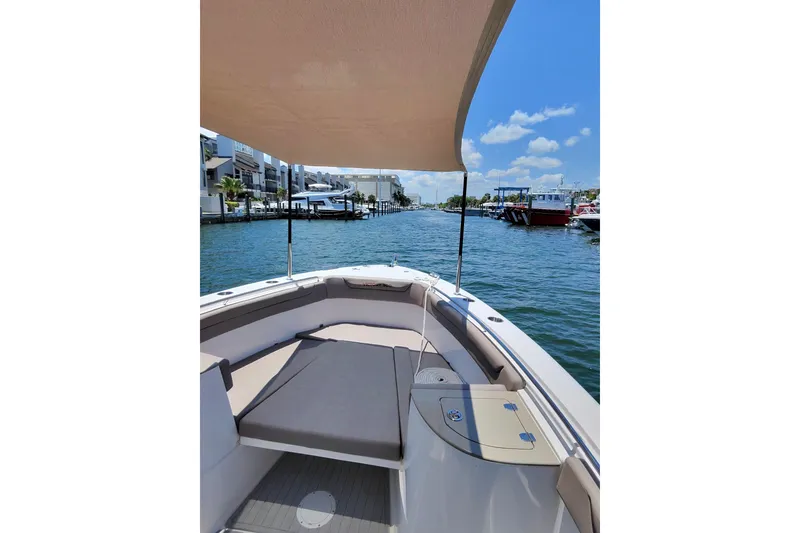 Slide: The Image of 2024 Victory Yachts V300 with sunshade, docked in a scenic marina. - 7