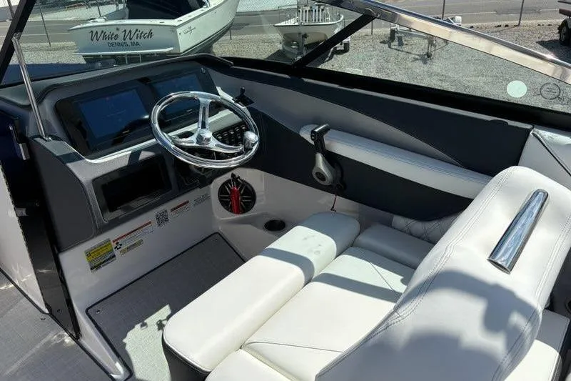 Slide: The Image of 2023 Regal LX4 boat interior with sleek steering wheel and white seating. - 11
