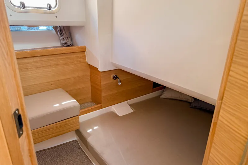 Slide: The Image of Cozy interior cabin of 2025 Nimbus Tender 11 with wooden accents and seating. - 26