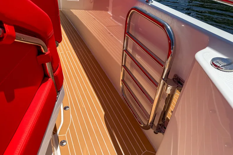 Slide: The Image of Red seating and chrome ladder on 2025 Nimbus Tender 11 boat deck. - 6