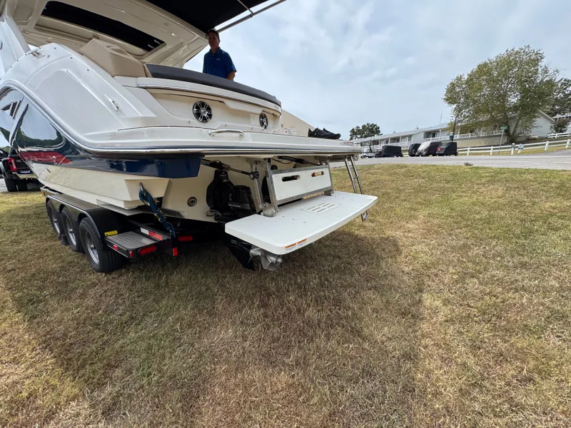 Slide: The Image of 2022 Sea Ray SLX 310 boat on trailer, rear view, parked on grass. - 10