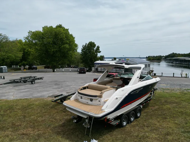 Slide: The Image of 2022 Sea Ray SLX 310 boat on trailer near waterfront and parking area. - 11