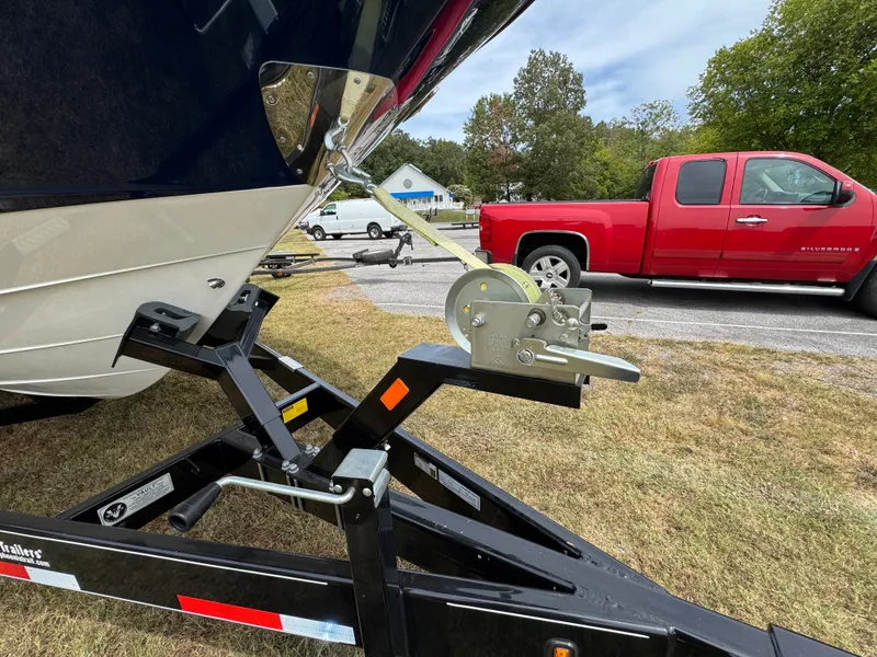 Slide: The Image of 2022 Sea Ray SLX 310 boat on trailer, parked near red truck. - 18