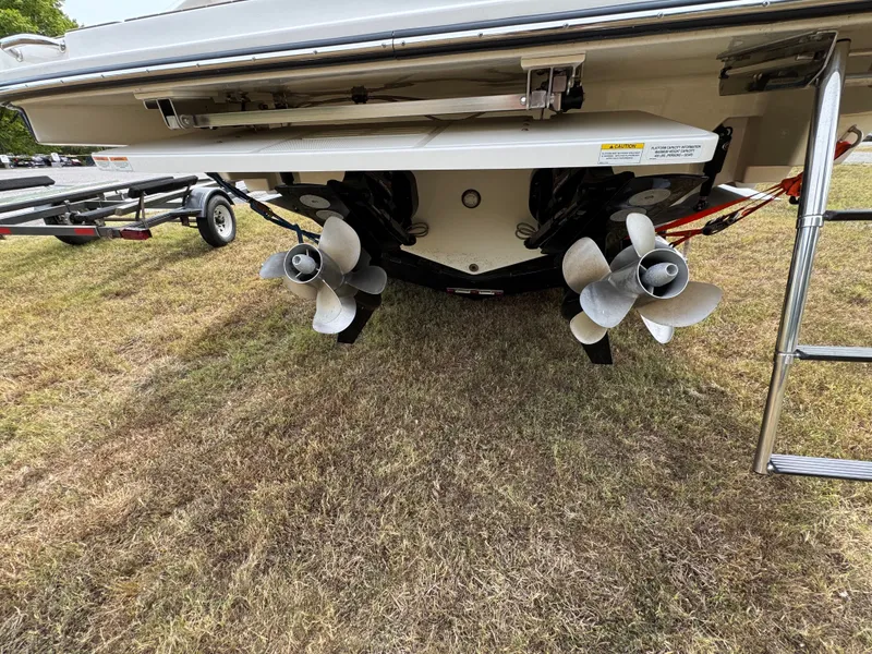 Slide: The Image of 2022 Sea Ray SLX 310 boat propellers and stern on grassy area. - 21