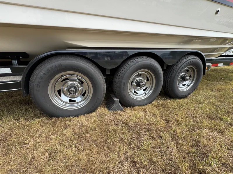 Slide: The Image of Trailer with triple axles for 2022 Sea Ray SLX 310 boat on grass. - 27