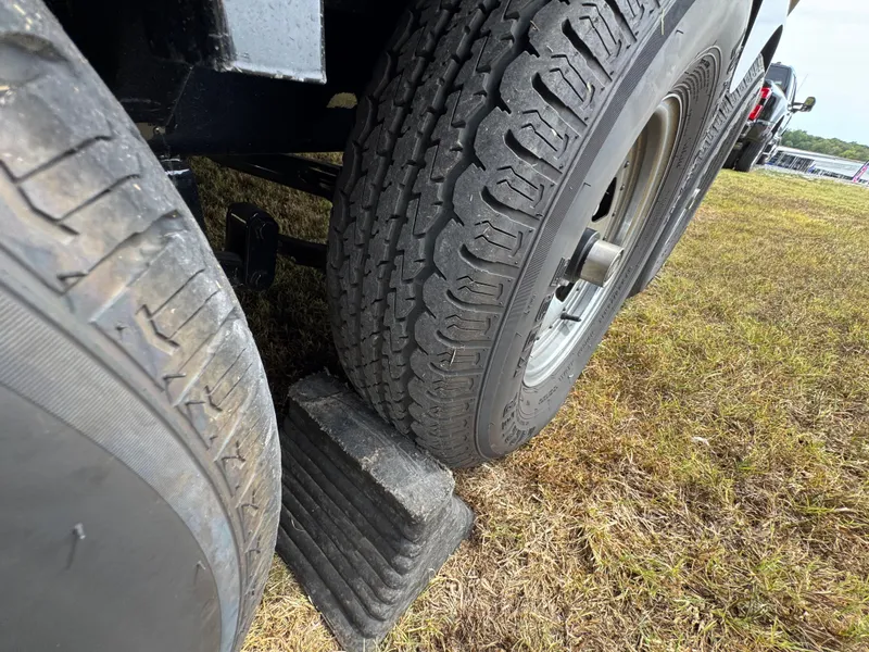 Slide: The Image of Close-up of trailer tires on grass, secured with a wheel chock. - 28