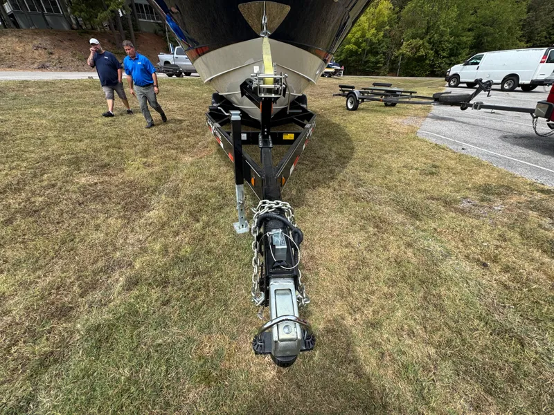 Slide: The Image of 2022 Sea Ray SLX 310 boat on trailer, parked on grass with people nearby. - 30