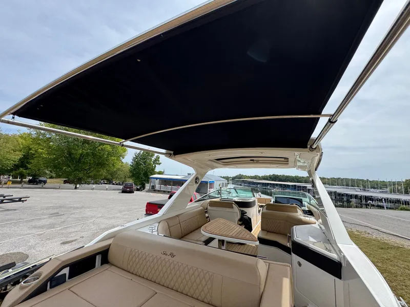 Slide: The Image of 2022 Sea Ray SLX 310 boat with spacious seating and canopy, docked outdoors. - 34