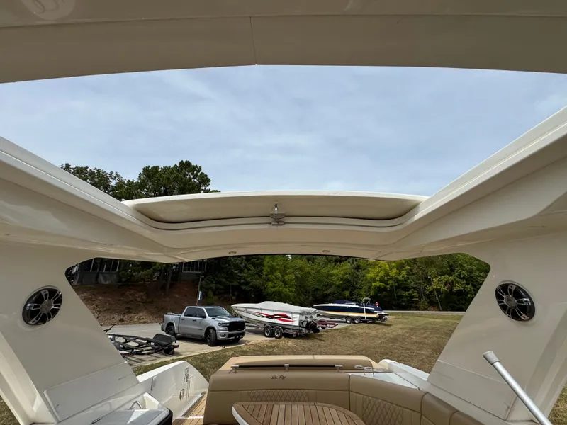 Slide: The Image of 2022 Sea Ray SLX 310 boat interior with open sunroof, parked on grassy area. - 38