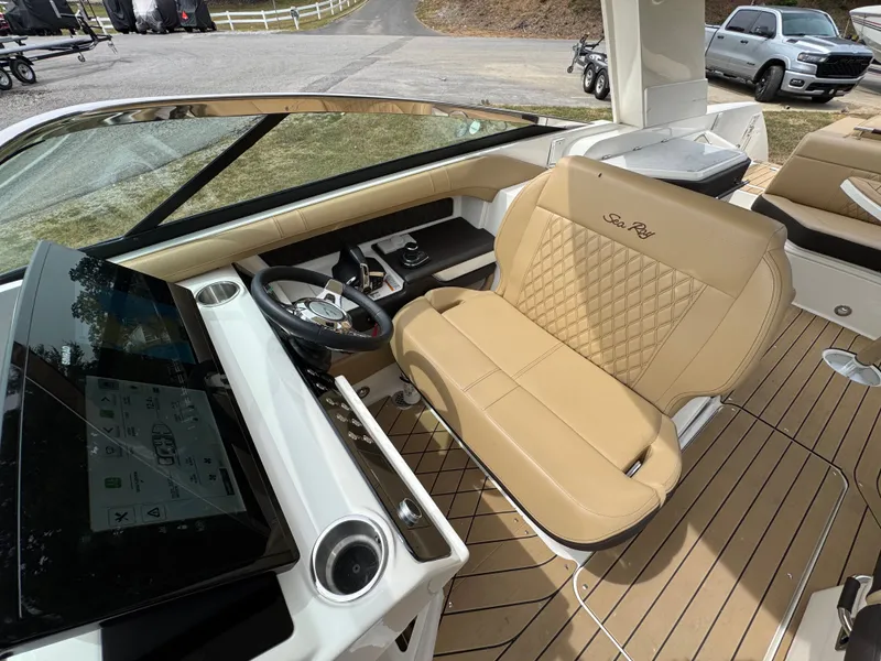 Slide: The Image of 2022 Sea Ray SLX 310 boat interior with tan leather seating and modern dashboard. - 49
