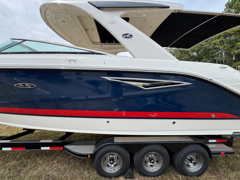 Slide: The Image of 2022 Sea Ray SLX 310 boat on trailer, blue and white with red stripe. - 5