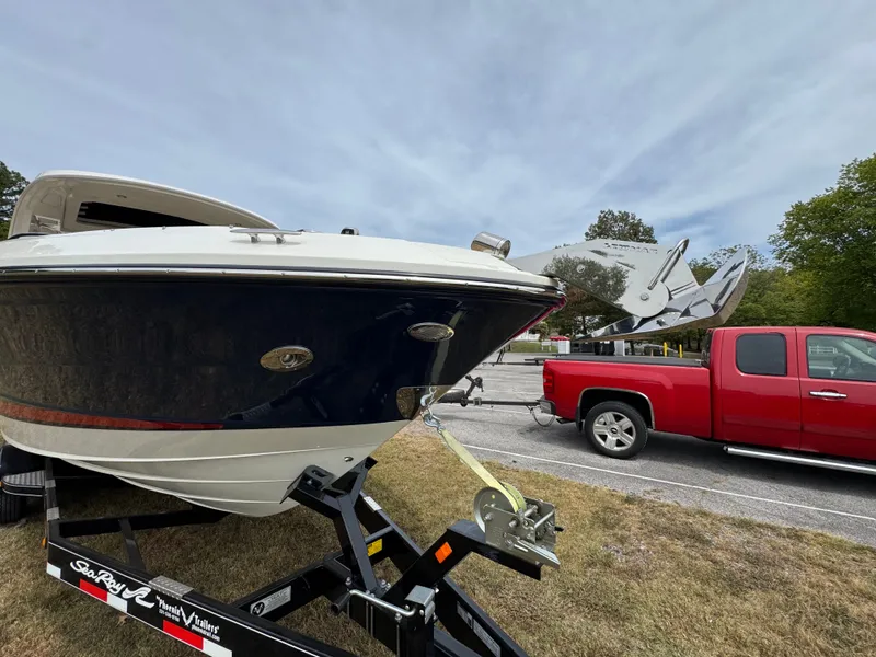Slide: The Image of 2022 Sea Ray SLX 310 boat on trailer, hitched to a red truck. - 7