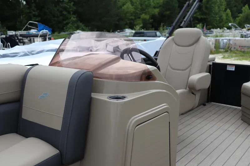 Slide: The Image of 2024 Starcraft 24 EX QDH boat interior with beige seating and steering console. - 5