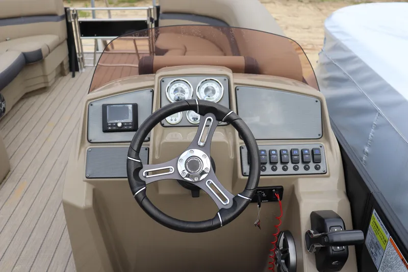 Slide: The Image of 2024 Starcraft 24 EX QDH boat dashboard with steering wheel and control panel. - 6