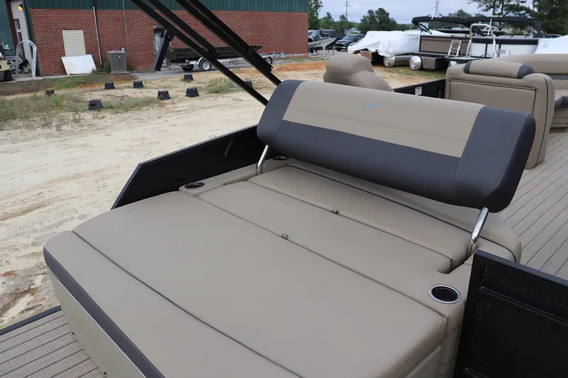 Slide: The Image of 2024 Starcraft 24 EX QDH boat with beige seating and cup holders. - 8