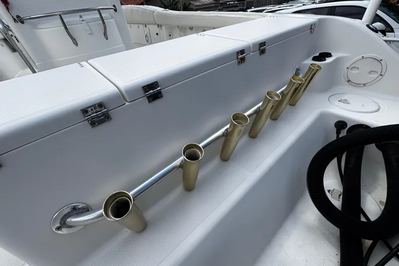 Slide: The Image of 2003 Triton 2895 CC boat interior with rod holders and storage compartments. - 18