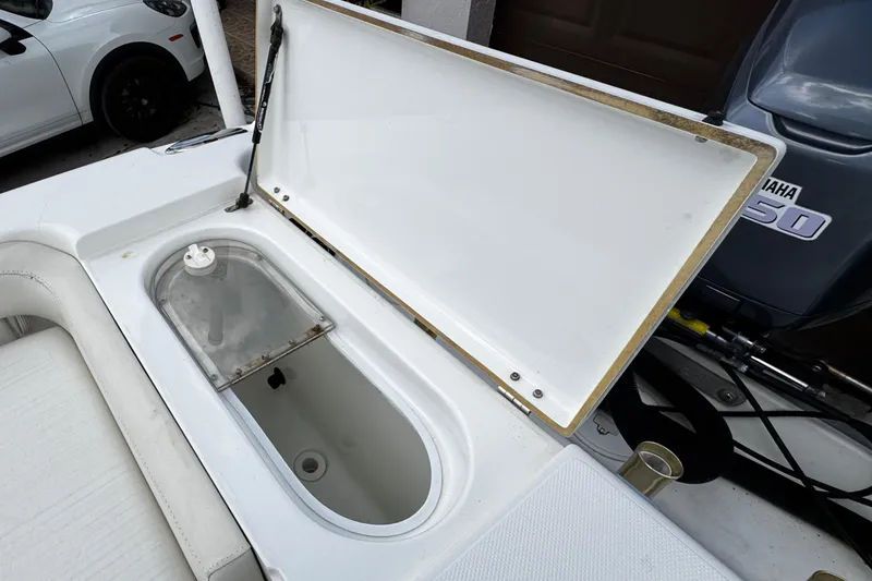 Slide: The Image of Open storage compartment on 2003 Triton 2895 CC boat, with visible Yamaha engine. - 26
