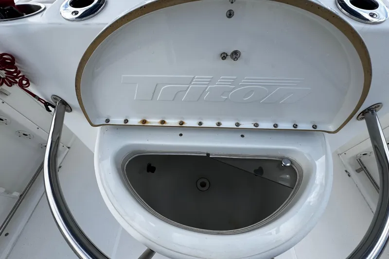 Slide: The Image of 2003 Triton 2895 CC boat interior with open storage compartment. - 27