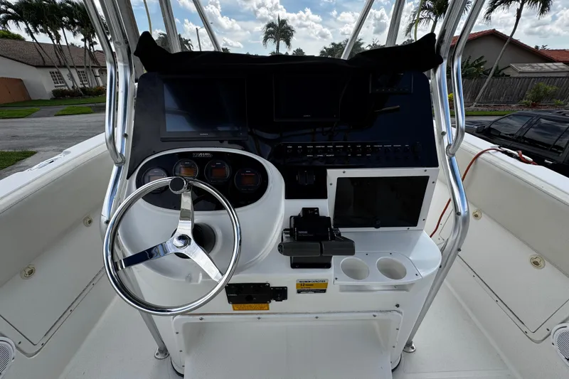 Slide: The Image of 2003 Triton 2895 CC boat helm with steering wheel and control panel. - 34