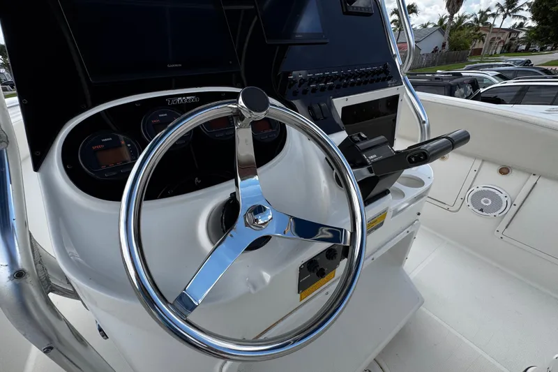 Slide: The Image of 2003 Triton 2895 CC boat helm with steering wheel and control panel. - 39