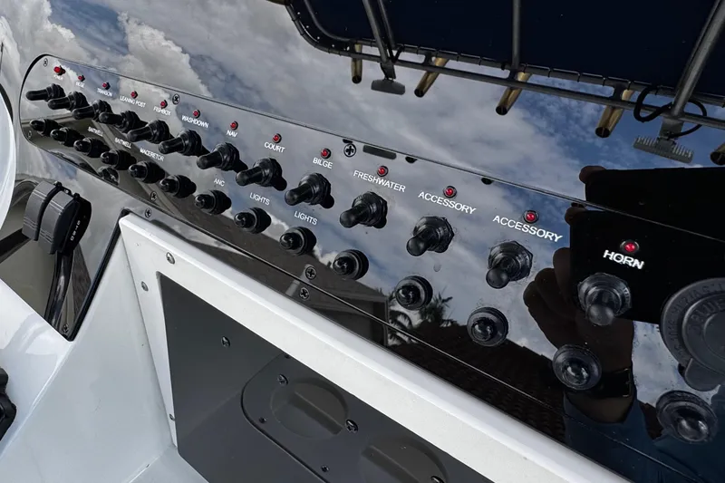 Slide: The Image of Control panel of a 2003 Triton 2895 CC boat with various switches and indicators. - 43