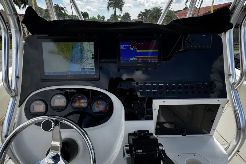 Slide: The Image of 2003 Triton 2895 CC boat dashboard with navigation screens and controls. - 47