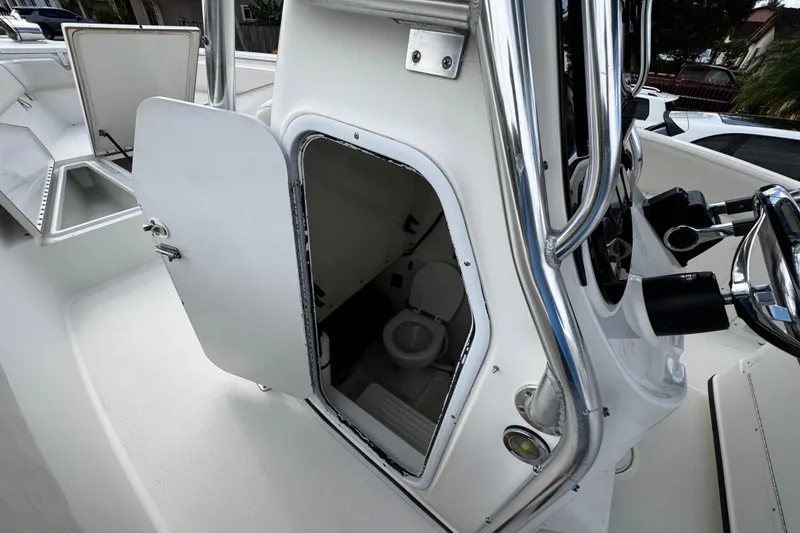Slide: The Image of 2003 Triton 2895 CC boat with open cabin door revealing interior toilet. - 48